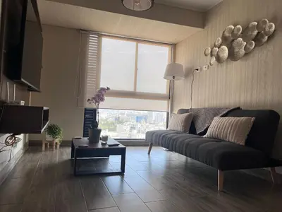 a living room with a couch and a large window at The Pool & City Spot - steps from Miraflores in Lima