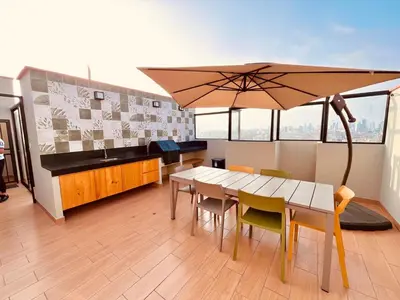 a dining room with a table and an umbrella at The Pool & City Spot - steps from Miraflores in Lima