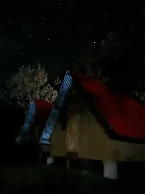 a small house with a red roof at night at Hostel el molle capulichayoc in Santa Teresa
