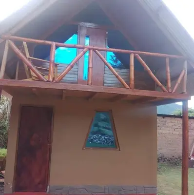 a house with a balcony on top of it at Hostel el molle capulichayoc in Santa Teresa