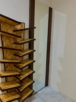 a wooden spiral staircase in a room with a wall at Habitación premium y moderna in La Merced