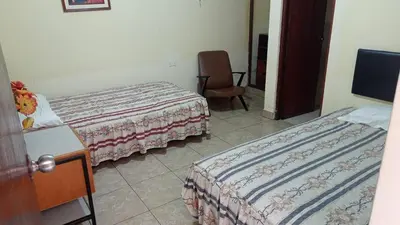 a hotel room with two beds and a chair at Hotel Perseo Inn in Barranca
