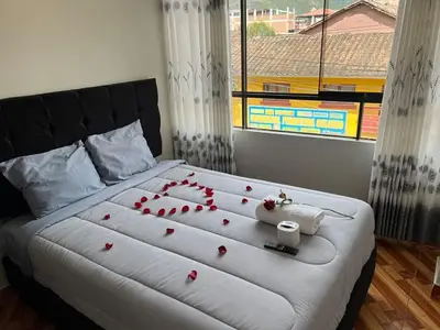 a bedroom with a large bed with roses on it at Hostal El Mariscal in Urubamba