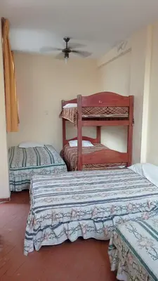 a bedroom with two beds and a ceiling fan at Hotel Perseo Inn in Barranca