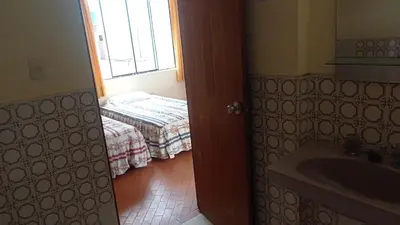 a bathroom with a room with a bed and a window at Hotel Perseo Inn in Barranca