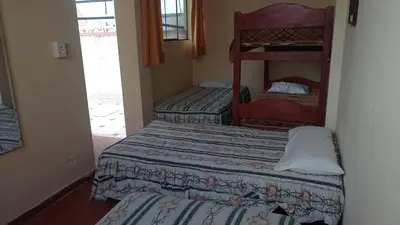 a room with two beds and a bunk bed at Hotel Perseo Inn in Barranca
