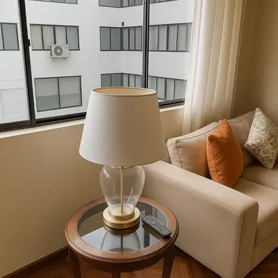 a lamp on a glass table next to a couch at Bello departamento en el corazón de Miraflores in Lima
