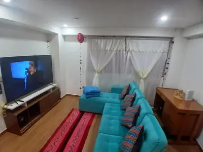 a living room with a blue couch and a flat screen tv at la casa de Alejandra in Cusco