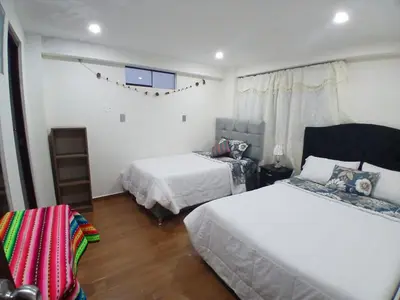 a bedroom with two beds and a window at la casa de Alejandra in Cusco