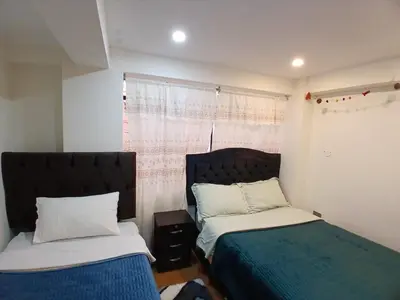 a bedroom with two beds and a window at la casa de Alejandra in Cusco