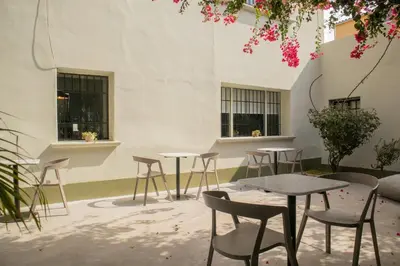 a group of tables and chairs in front of a building at Casa la Paz by Wynwood House in Lima