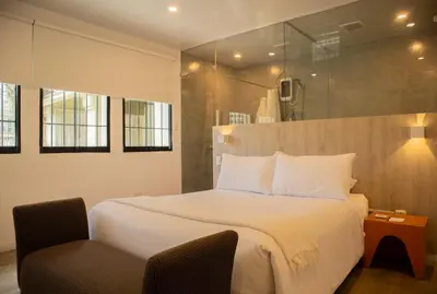 a bedroom with a large white bed and a chair at Casa la Paz by Wynwood House in Lima