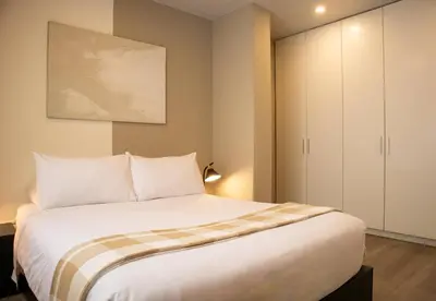 a bedroom with a large white bed and a cabinet at Casa la Paz by Wynwood House in Lima