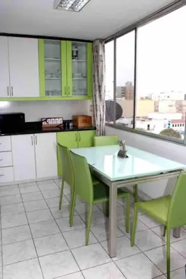 a kitchen with green cabinets and a table and chairs at Great Location near to everything! in Lima