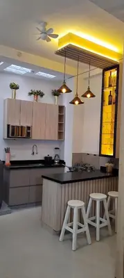 a kitchen with a counter and two stools in it at ideal depa lujo con cocina wifi in Puente Piedra