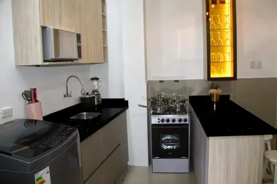a small kitchen with a stove and a sink at ideal depa lujo con cocina wifi in Puente Piedra