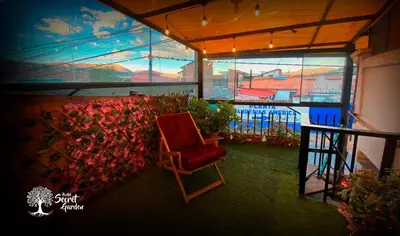 a red chair in a room with a wall of flowers at Taytacha House in Cusco