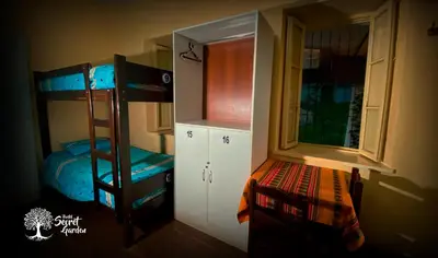 a room with two bunk beds and a window at Taytacha House in Cusco