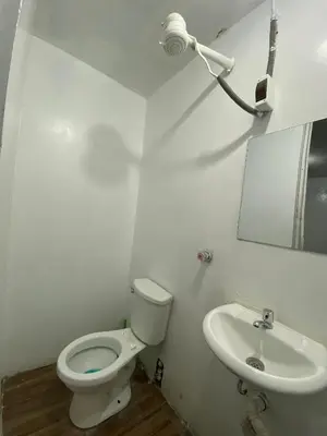 a white bathroom with a toilet and a sink at Allawaska Hostel & Camping in Laguna Huacachina