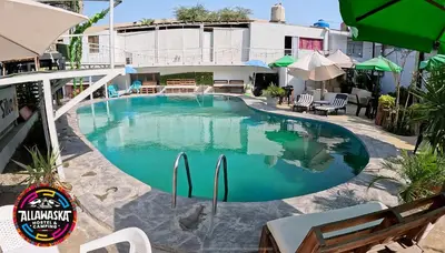a large swimming pool in front of a building at Allawaska Hostel & Camping in Laguna Huacachina