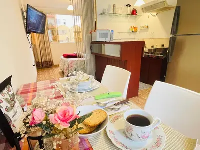a table with a plate of food and a cup of coffee at Luminoso minidepartamento independiente cerca al Estadio Nacional in Lima