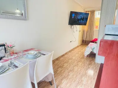 a dining room with a table and a tv on the wall at Luminoso minidepartamento independiente cerca al Estadio Nacional in Lima
