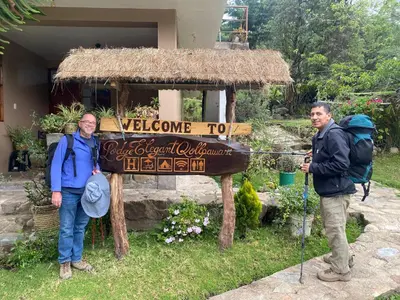two men standing in front of a welcome sign at Eco Lodge Elegant Qollpawasi in Colcapampa