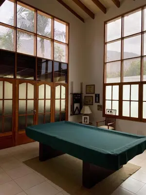 a pool table in a room with windows at Casa Vaí Cieneguilla with a pool in Cieneguilla