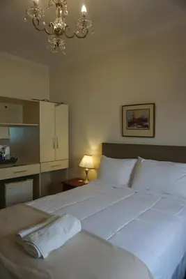 a bedroom with a large white bed with a chandelier at Kontiki Miraflores in Lima