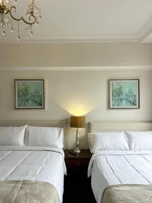a bedroom with two beds and a lamp on a table at Kontiki Miraflores in Lima
