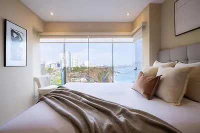 a bedroom with a large bed with a large window at ALU Apartments - Ocean View at Larcomar Miraflores Next to JW Marriott in Lima