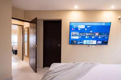 a bedroom with a flat screen tv on the wall at ALU Apartments - Ocean View at Larcomar Miraflores Next to JW Marriott in Lima