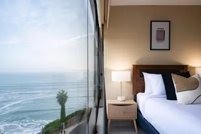 a bedroom with a bed and a view of the ocean at ALU Apartments - Ocean View at Larcomar Miraflores Next to JW Marriott in Lima