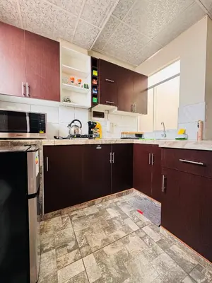 an empty kitchen with brown cabinets and a sink at La CASITA in Cusco