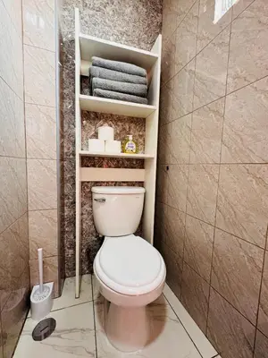 a bathroom with a white toilet and towels at La CASITA in Cusco