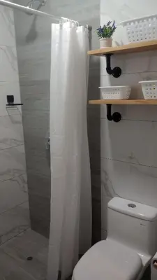a bathroom with a white shower curtain and a toilet at Travel & Home Place in Lima