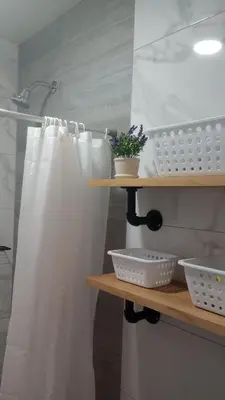 a bathroom with a shower with a white shower curtain at Travel & Home Place in Lima