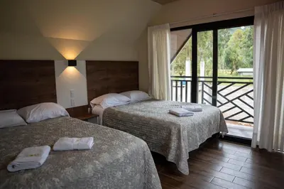 a hotel room with two beds and a balcony at Prana Cabins Oxapampa in Oxapampa