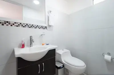 a white bathroom with a sink and a toilet at DivarAparts#1 in Lima