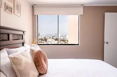 a bedroom with a bed with a large window at DivarAparts#1 in Lima