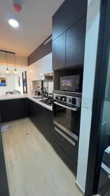 a kitchen with black cabinets and a stove top oven at Miraflores Deluxe in Lima
