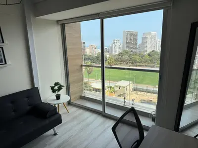 a living room with a couch and a large window at BR1 Barranco Exclusive Department in Lima