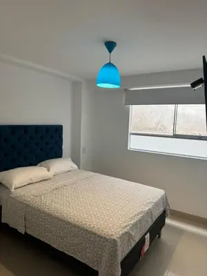 a bedroom with a bed and a blue light at Beautiful apartment with an ocean view in San Bartolo