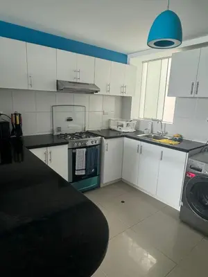 a kitchen with white cabinets and a stove top oven at Beautiful apartment with an ocean view in San Bartolo