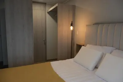 a bedroom with a white bed and a lamp at Cozy apartment in Barranco in Lima