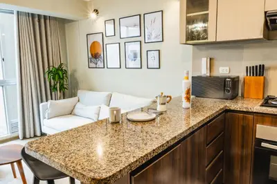 a kitchen with a counter top and a living room at Cozy apartment in Barranco in Lima