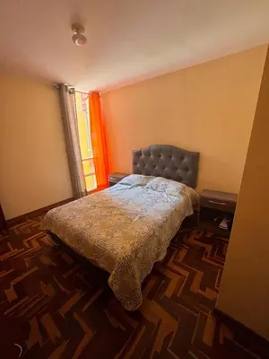 a bedroom with a bed in a room with a window at Departamento in Lima