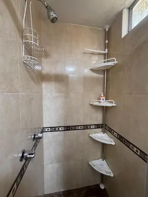 a shower with three shelves in a bathroom at Departamento in Lima