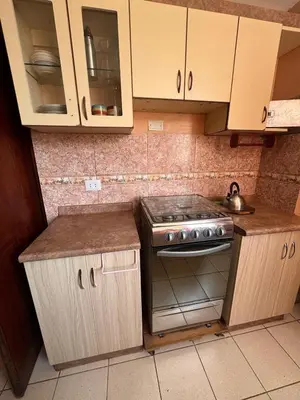 a kitchen with a stove and cabinets and a sink at Departamento in Lima