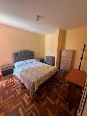 a bedroom with a bed and a wooden floor at Departamento in Lima